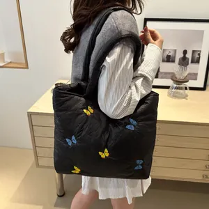 Sac fourre-tout matelassé noir avec broderies papillons colorées et texture moelleuse