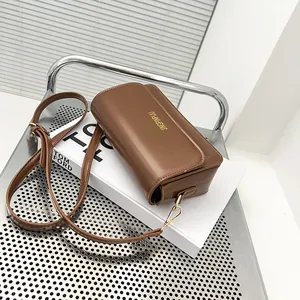 Chic brown leather baguette bag on a fashion book for a classic retro shoulder look
