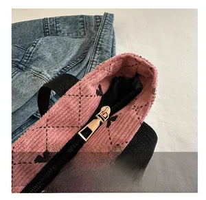 Nahaufnahme der rosa Cord-Tragetasche mit gesteppter Textur und schwarzem Reißverschluss