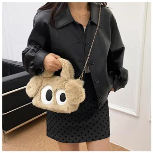 Détail d'un sac peluche chiot avec grands yeux et bandoulière en chaîne dorée pour femme