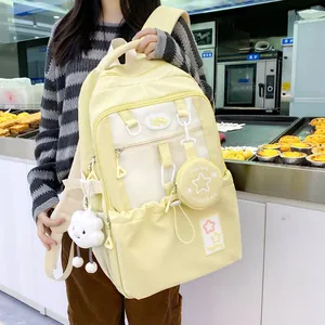 Close-up of yellow backpack featuring decorative star patches and plush cloud accessory