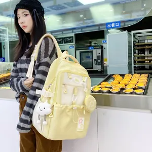 Detail of cream school backpack with multiple pockets and cute cloud plush charm