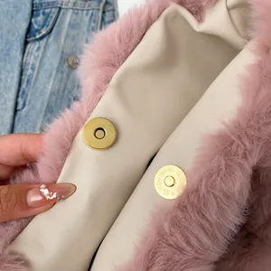 Detailed macro view of the pink faux fur bag featuring its secure gold magnetic snap closure