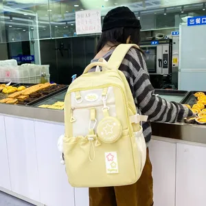 Detail view of a pale yellow nylon backpack with a round mini coin purse and star pattern