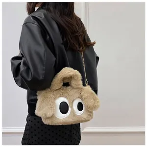 Détail du sac chiot en peluche avec grands yeux, texture douce et chaîne dorée chic