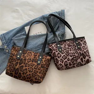 Detail of leopard print tote bags in warm brown and cool grey with black rivet straps