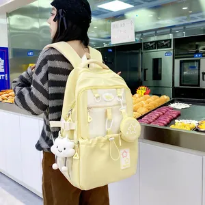 Detail of light yellow nylon backpack with heart tags and cloud plush charm