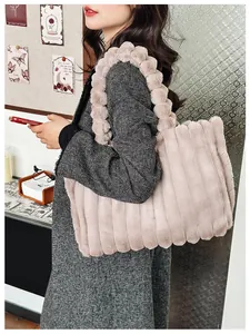 Détail du sac cabas en fausse fourrure rose séchée avec poignée en boules pelucheuses