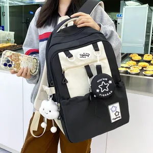 Detail of black and white student backpack with mini charm and plush cloud accessory