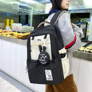 Detail view of black and white canvas school backpack with star patterns and mini pouch