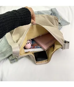 Spacious interior of khaki nylon crossbody bag showing large storage capacity for items