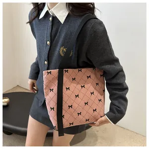 Detailansicht der rosa Cord-Tragetasche mit schwarzen Schleifenprints und Steppmuster