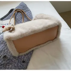 Detail of plush faux fur tote with leather base and a cute reindeer charm accessory