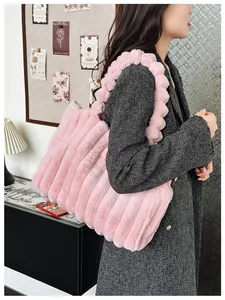 Sac cabas en fausse fourrure rose avec matelassage vertical et bandoulière à pompons