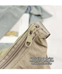 Detailed macro view of the front zipper and nylon texture on the beige shoulder bag