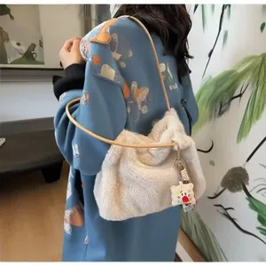 Detail of soft cream faux fur shoulder bag with slender brown leather strap on model