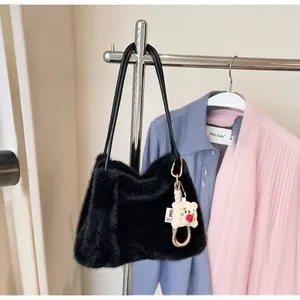Detail of black faux fur tote bag with a cute white bear charm on a metal hanger