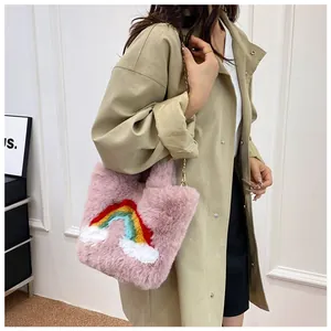 Detail of pink faux fur handbag with rainbow cloud patch and gold chain strap