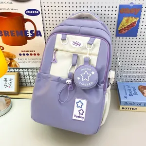 Detail view of lavender and beige minimalist backpack with a mini charm on a study desk