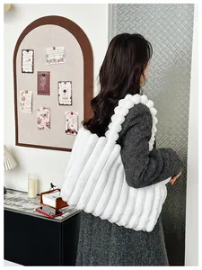 Détail d'un sac cabas en peluche blanche avec poignée à bulles et texture rayée douce