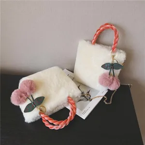 Winter plush crossbody bag in white faux fur with velvet woven handle and cherry charm detail