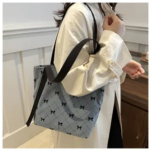 Detail der blauen Cord-Tasche mit gestepptem Muster und schwarzen Bogenstickereien
