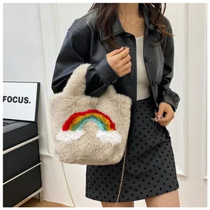 Detailed close-up of plush beige handbag featuring rainbow embroidery and gold chain strap