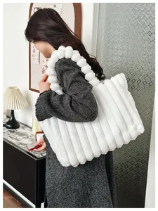 Vue détaillée du cabas en peluche blanche avec rayures verticales et pompons assortis