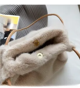 Detail of plush faux fur tote with golden magnetic buckles and leather strap