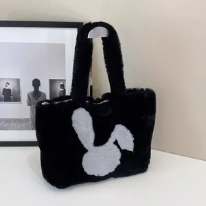 Detail shot of black plush tote bag with a white bunny rabbit pattern and soft texture