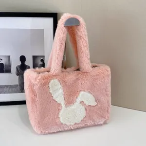 Detail of soft pink plush tote bag with white bunny silhouette and fuzzy texture