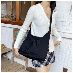 Detail of black nylon pleated dumpling bag with drawstring and adjustable strap