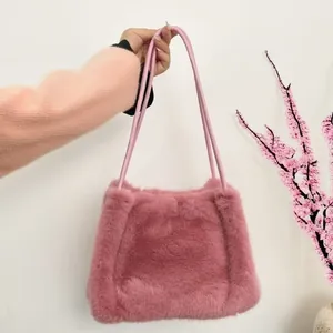 Detail of pink faux fur shoulder bag featuring soft texture and matching dual straps