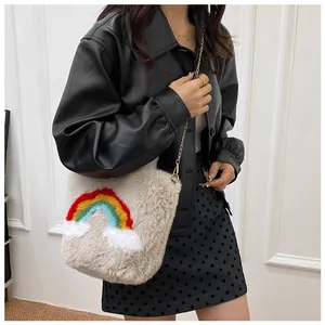 Close-up of fluffy white faux fur texture with vibrant rainbow embroidery and gold chain