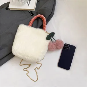 Detail of white faux fur handbag with pink braided handle and cherry charms