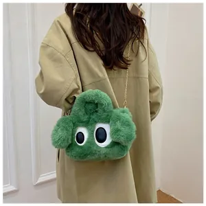 Détail du sac à main peluche chien vert avec de grands yeux et une bandoulière dorée