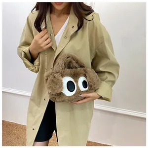 Détail du sac en peluche marron avec grands yeux de dessin animé et fine chaîne dorée