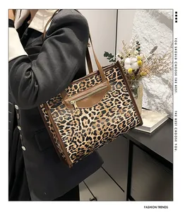 Close-up of leopard print tote bag featuring a practical gold front zipper and brown trim