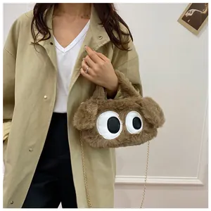Sac en peluche marron à yeux de dessin animé porté par un mannequin en manteau