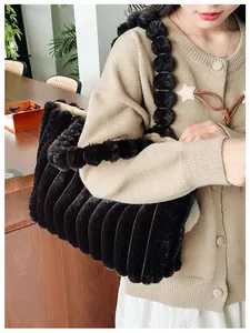 Détail du sac cabas en fausse fourrure noire avec texture plissée et bandoulière à pompons