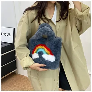 Grey plush handbag with rainbow design and gold chain shown on a model