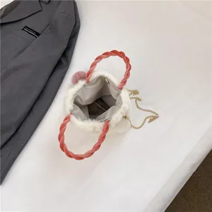 Winter plush white handbag with pink twisted handle, gold chain strap and pompom charm