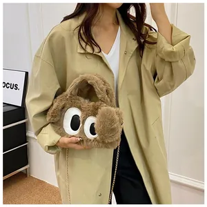 Détail du sac peluche chien avec grands yeux de dessin animé et chaîne dorée chic