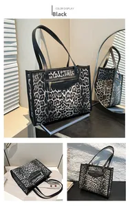 Detail view of the black leopard print tote bag featuring a front zipper pocket and strap