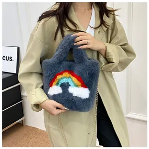 Detail of grey faux fur handbag with rainbow patch, plush texture and gold chain strap