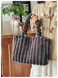 Gros plan sur un sac en peluche gris à rayures avec poignée à boules unique