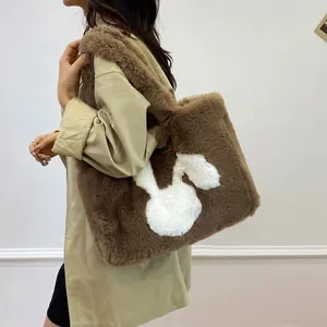 Detailed view of brown plush tote bag featuring a cute white bunny applique on the shoulder