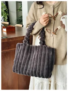 Détail du cabas en fausse fourrure grise avec texture pelucheuse et poignée à pompons