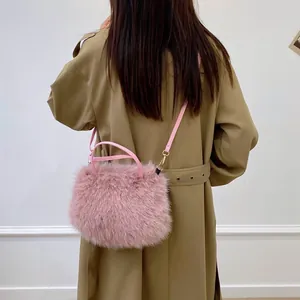 Sac à main rose en fausse fourrure avec bandoulière en cuir et boucles dorées