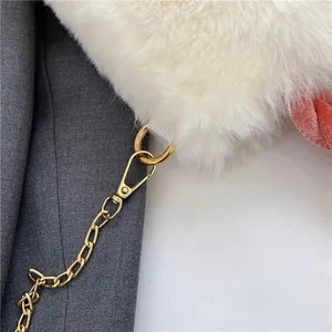 Close-up of white plush handbag featuring gold metal chain and soft velvet detail